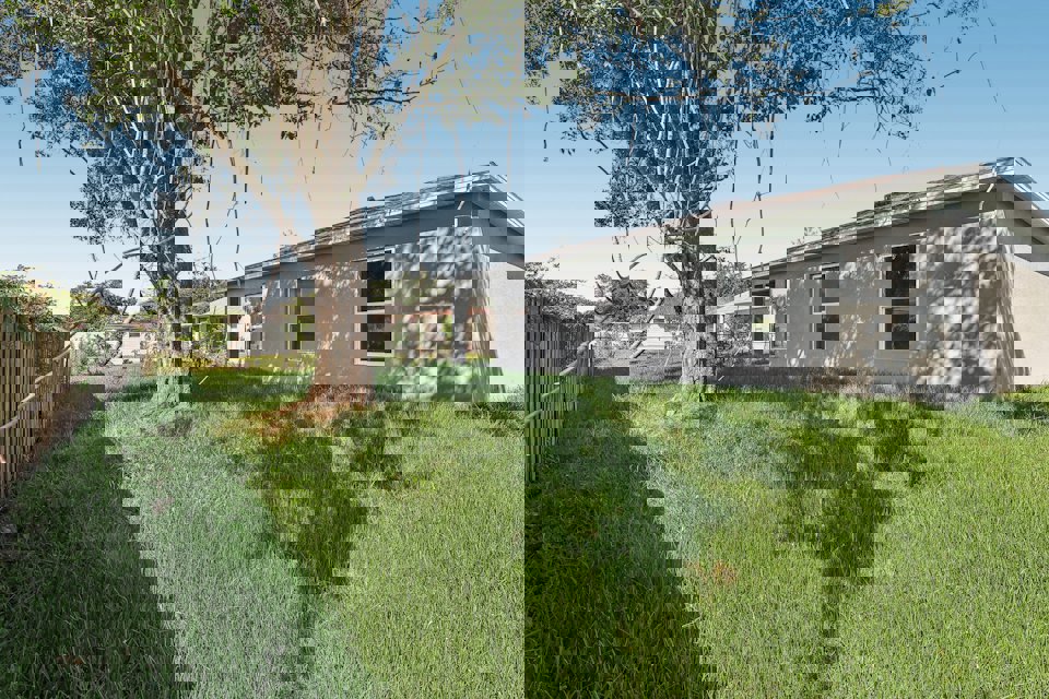 A house with a fence and trees.