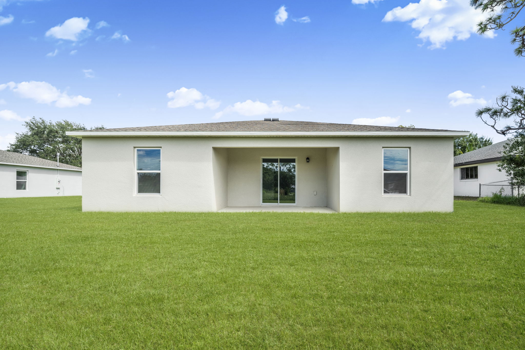 A white house with a green lawn.