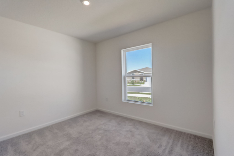 A room with a window and carpet.