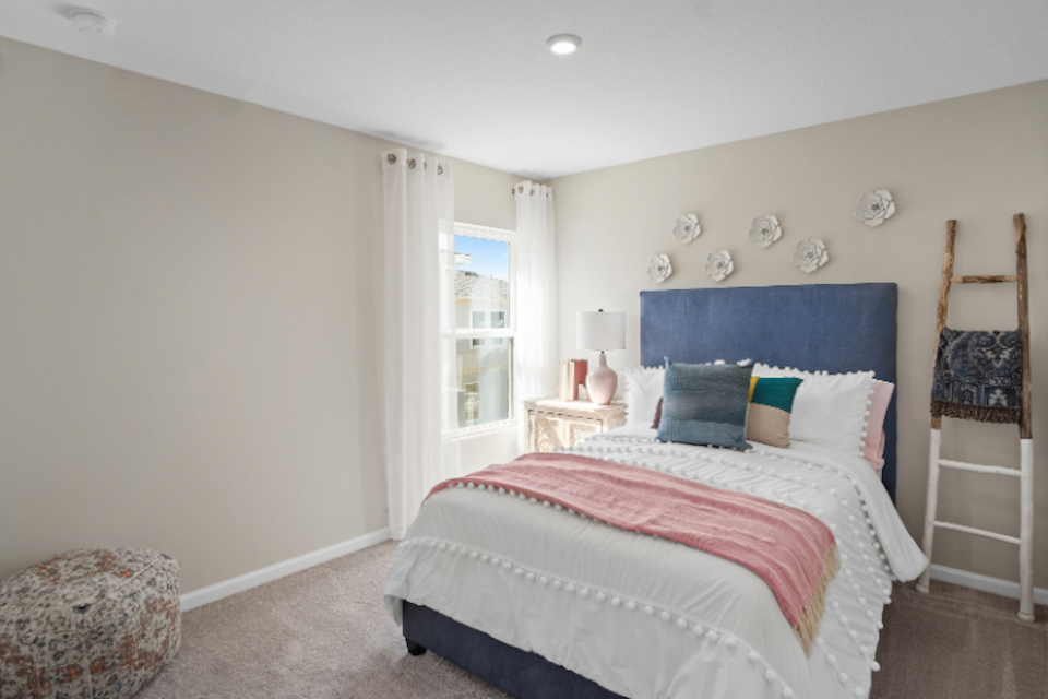 A bedroom with a bed and a chair.