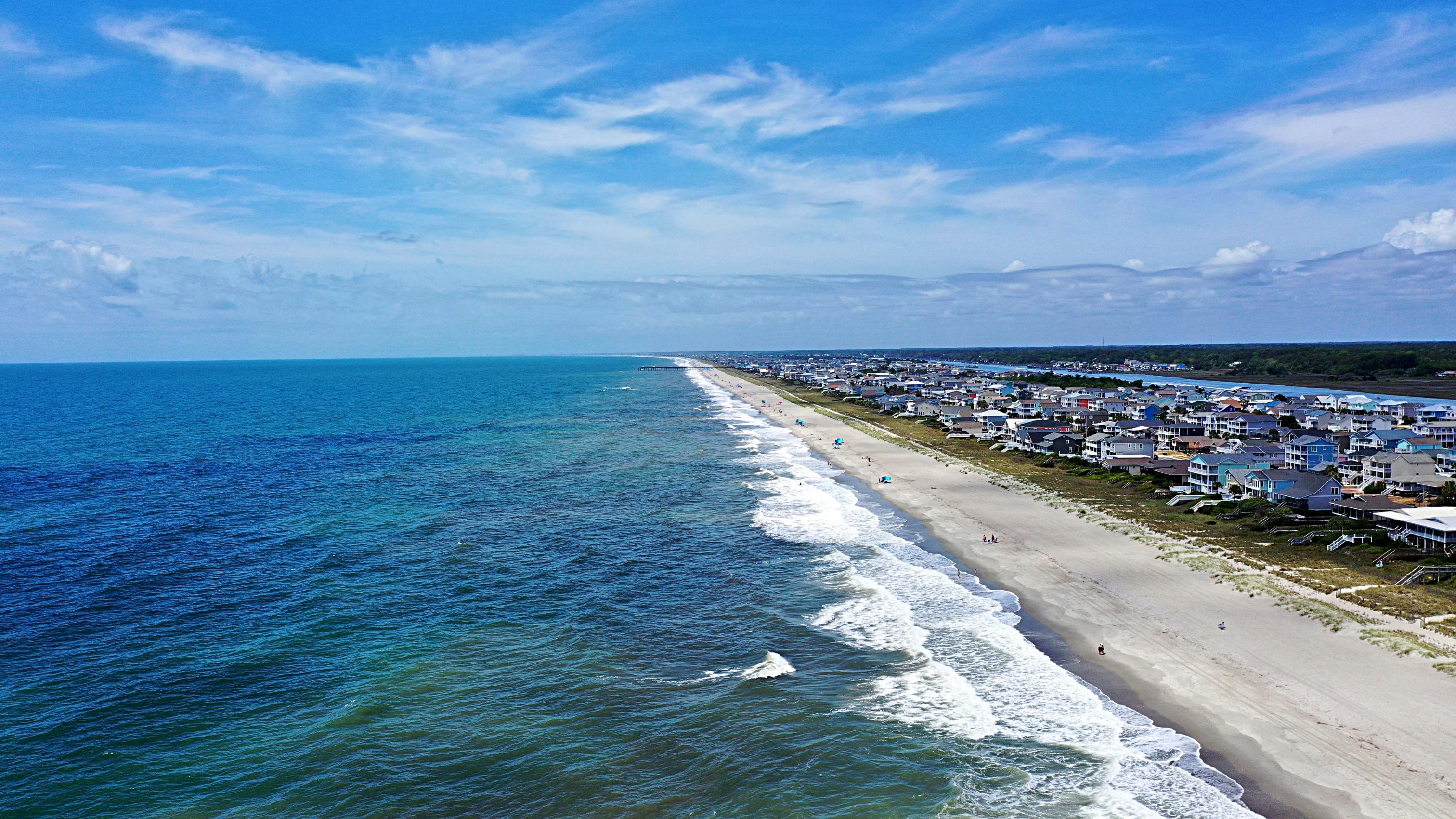 A beach with houses along it.