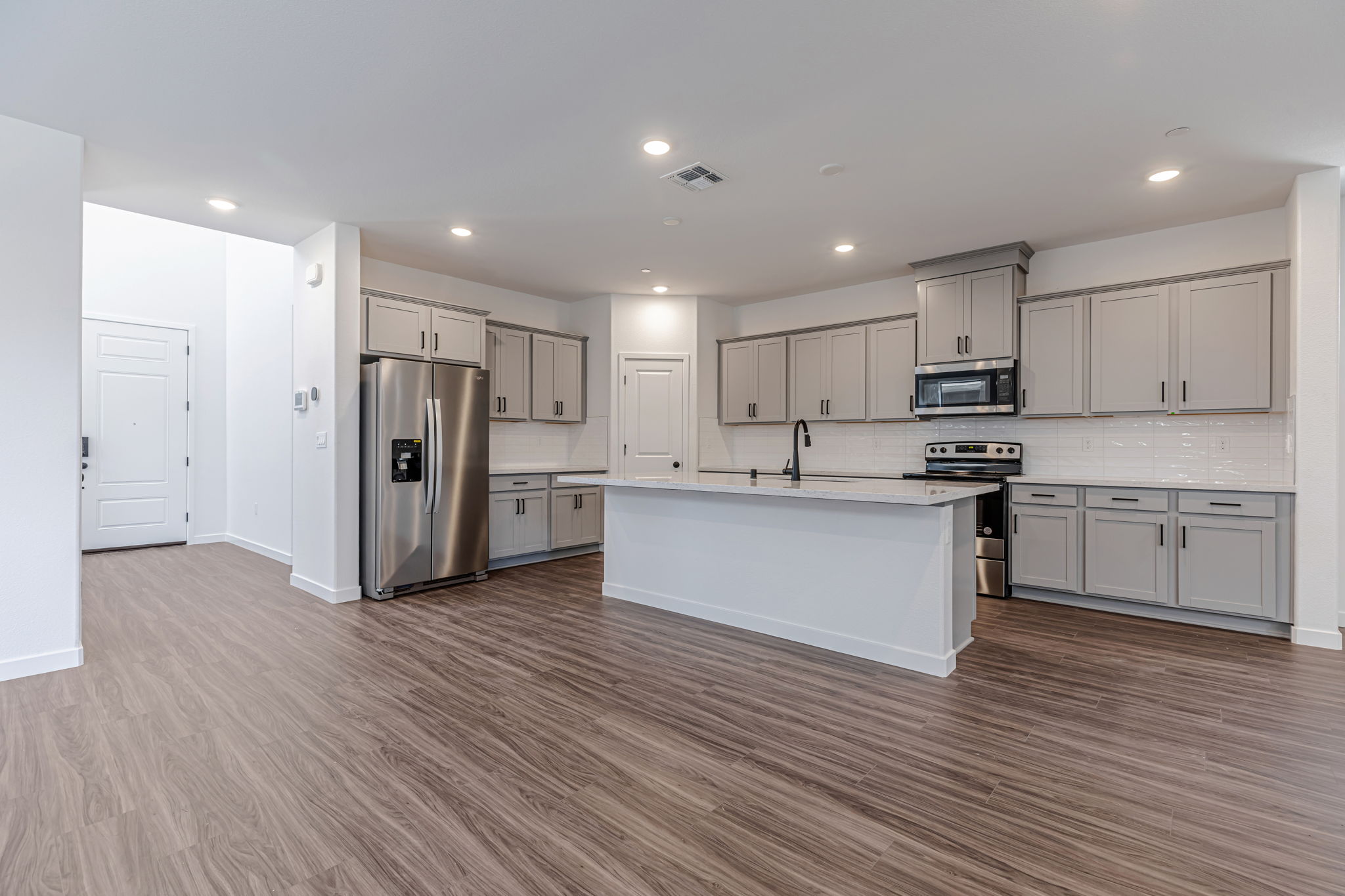 A kitchen with white cabinets.